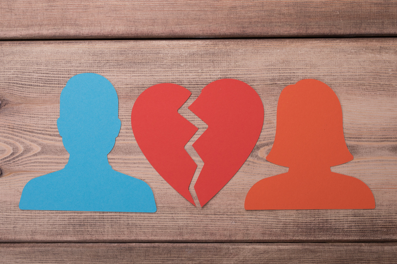 Umriss eines Manns und einer Frau und ein gebrochenes Herz.